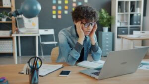Professional woman experiencing Imposter Syndrome symptoms at work