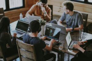 Hidden cost of Imposter Syndrome in teams Team meeting where Imposter Syndrome causes employees to stay silent
